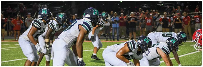 A football player wearing a blue and white uniform. Description generated by AI