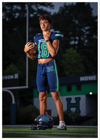 A football player wearing a blue and red jersey. Description generated by AI