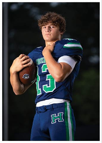 A football player wearing a blue and red jersey. Description generated by AI