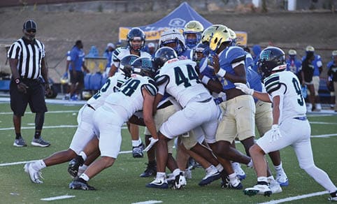 Two men wearing football uniforms are hugging each other on a field. AI generated content