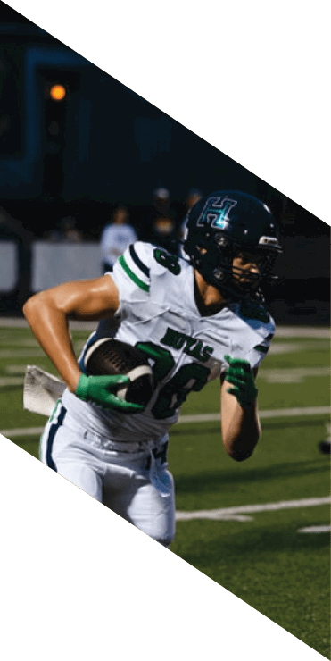 Two football players are on the field, one jumping in the air while the other is running. A referee is also present, watching the play. AI generated content