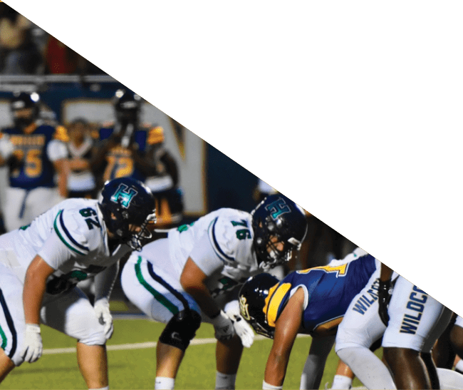 A group of football players kneeling on the field, some with their hands on their heads. AI generated content