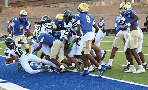Two men wearing football uniforms are hugging each other on a field. AI generated content