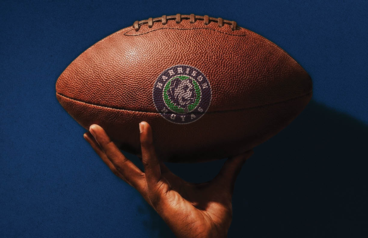 A football is being held by a person. Description generated by AI