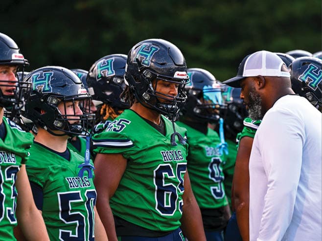 A group of football players in black and white uniforms are on the field. AI generated content