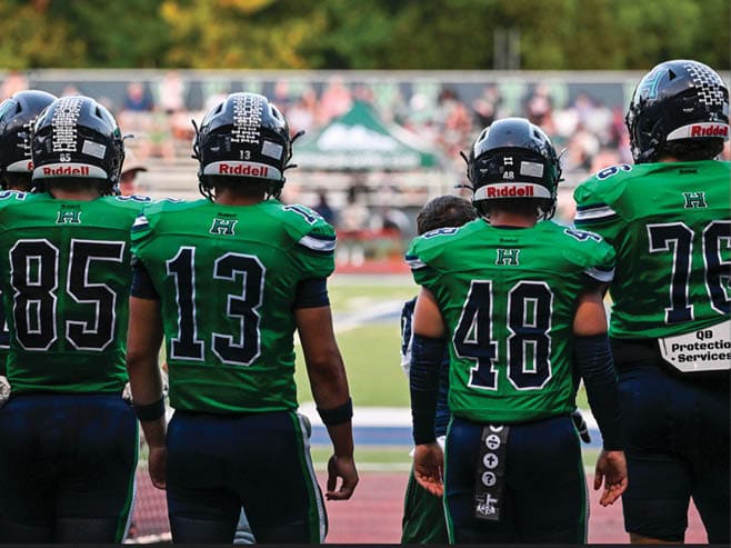 A group of football players in black and white uniforms are on the field. AI generated content