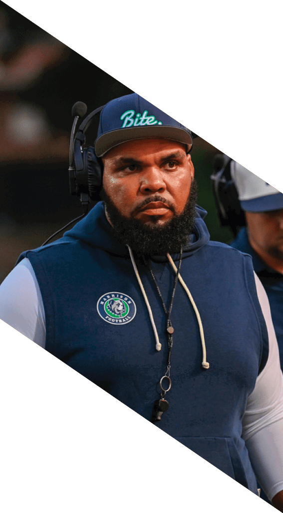 A football player wearing a black helmet and white jersey is holding a football in his hands. AI generated content