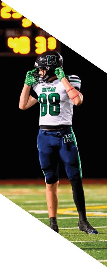 A football player wearing a helmet and white uniform is holding his helmet above his head. AI generated content