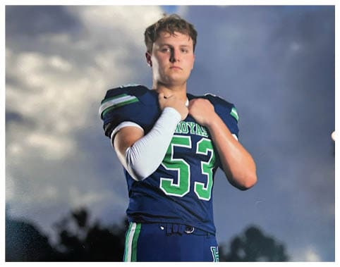 A football player wearing a blue and red jersey. Description generated by AI