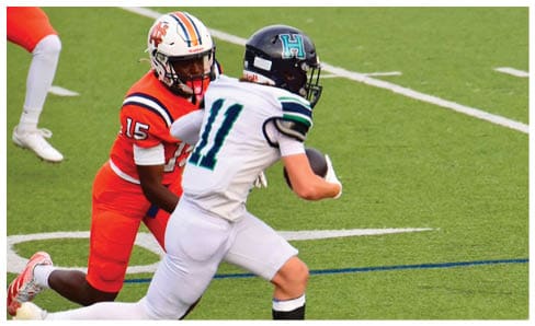 Two men wearing football uniforms are hugging each other on a field. AI generated content