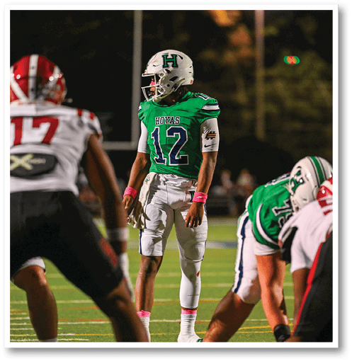 A football player wearing a black jersey with the number 6 on it. Description generated by AI