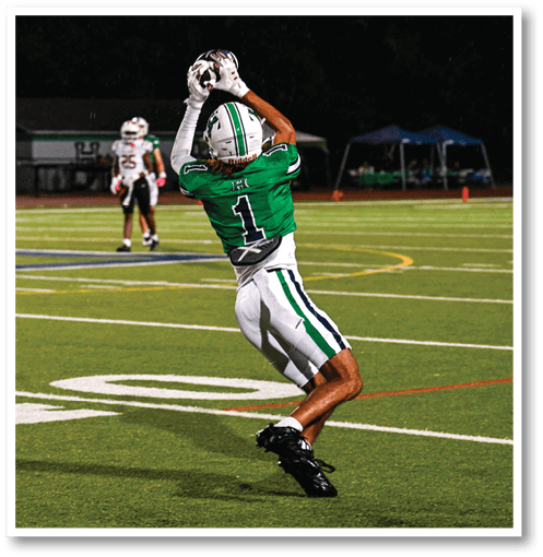 A football player wearing a black jersey with the number 6 on it. Description generated by AI