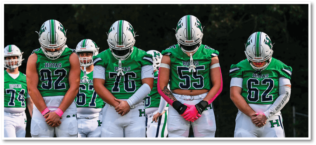 A group of football players on a field. Description generated by AI
