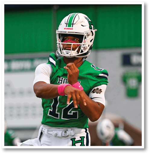 A football player wearing a black jersey with the number 6 on it. Description generated by AI