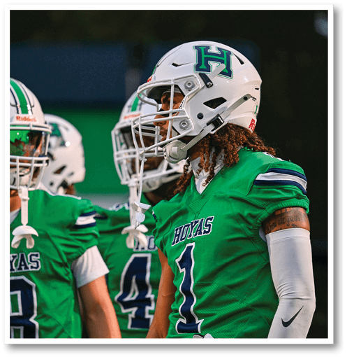 A football player wearing a black jersey with the number 6 on it. Description generated by AI