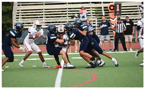 Two men wearing football uniforms are hugging each other on a field. AI generated content