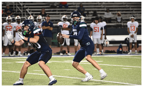 Two men wearing football uniforms are hugging each other on a field. AI generated content