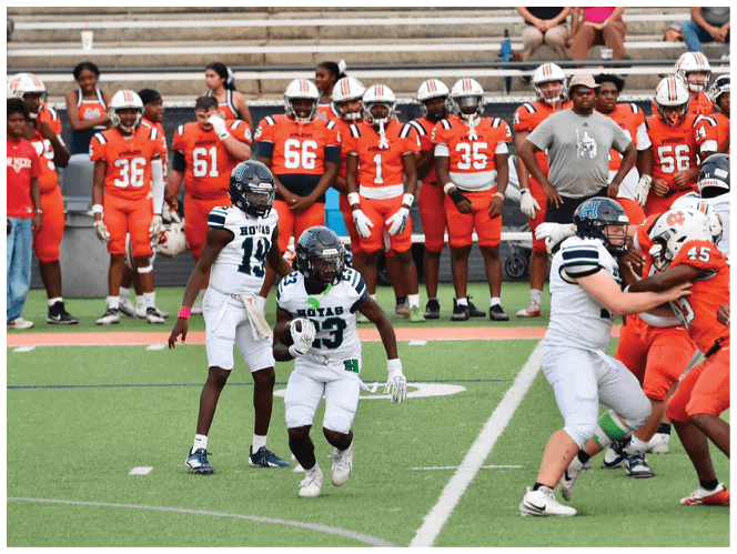 A group of football players in black and white uniforms are on the field. AI generated content