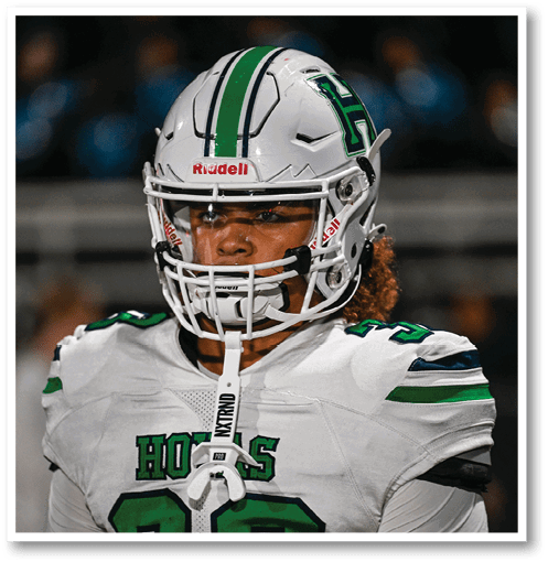 A football player wearing a black jersey with the number 6 on it. Description generated by AI