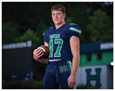 A football player wearing a blue and red jersey. Description generated by AI