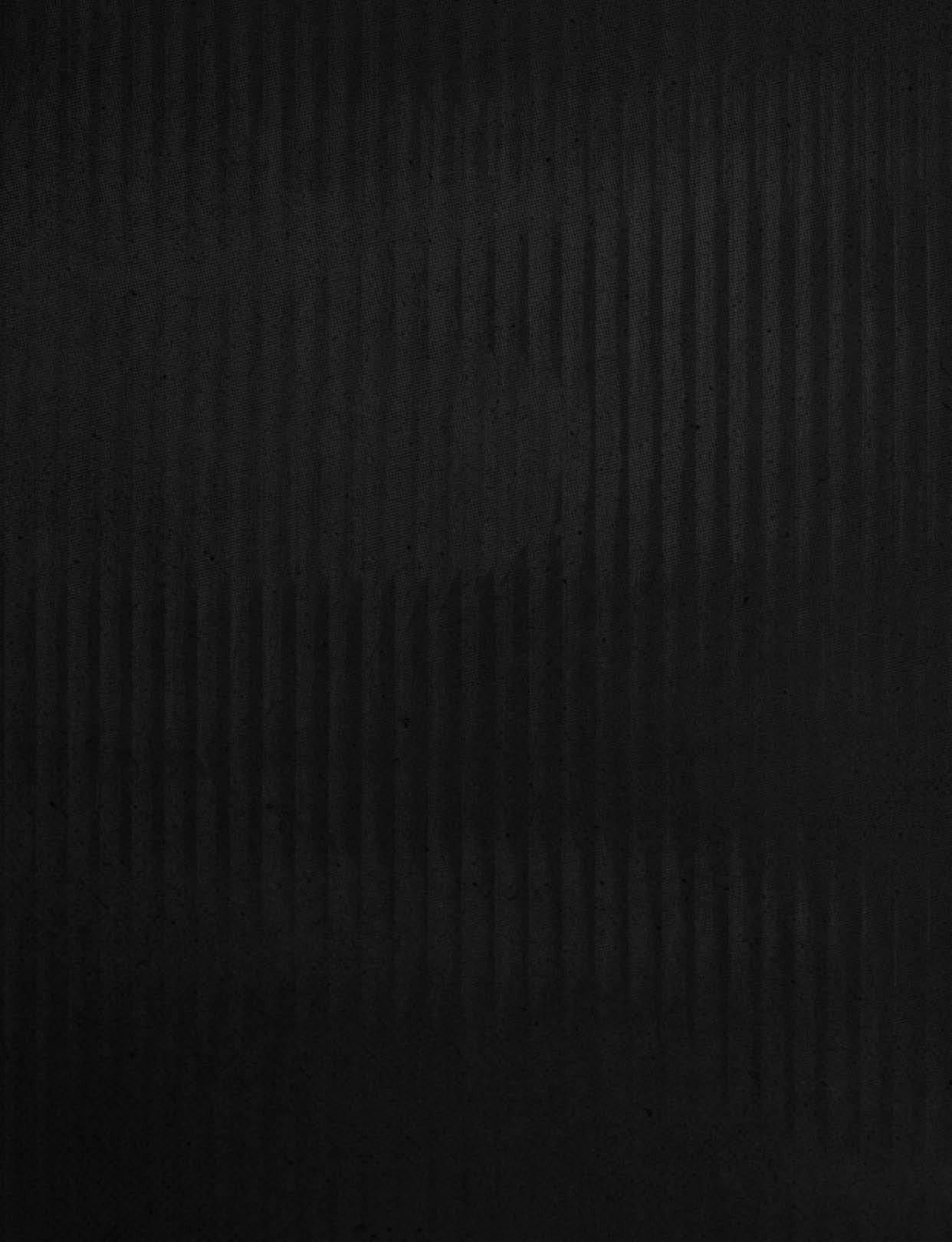 A dark textured surface with subtle vertical ridges and faint shadow patterns. Description generated by AI