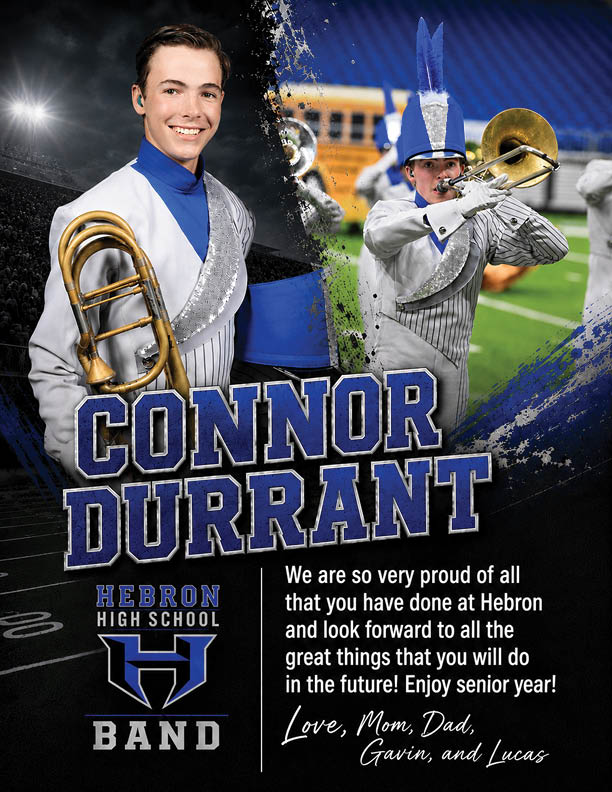 A person in a blue and white marching band uniform is smiling and holding a brass instrument with a stadium crowd and bright lights in the background. Description generated by AI