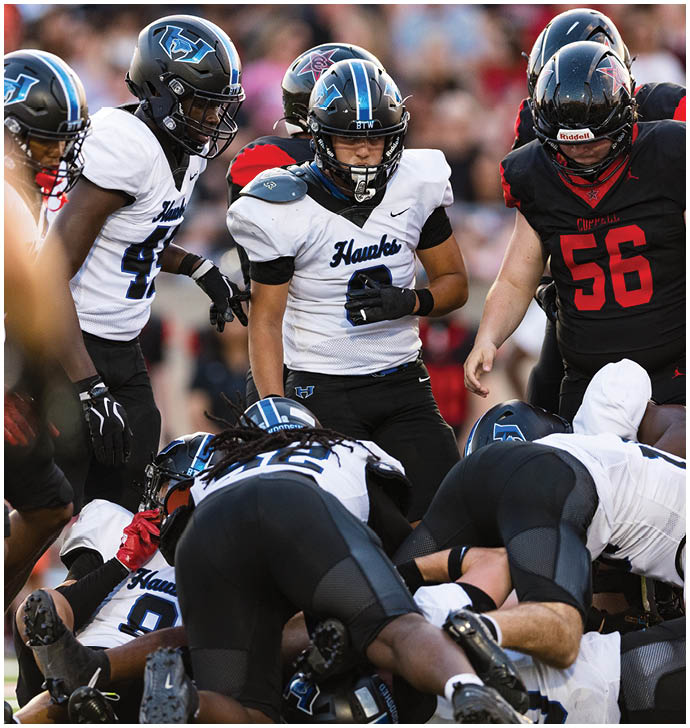A group of football players wearing black and white uniforms. Description generated by AI