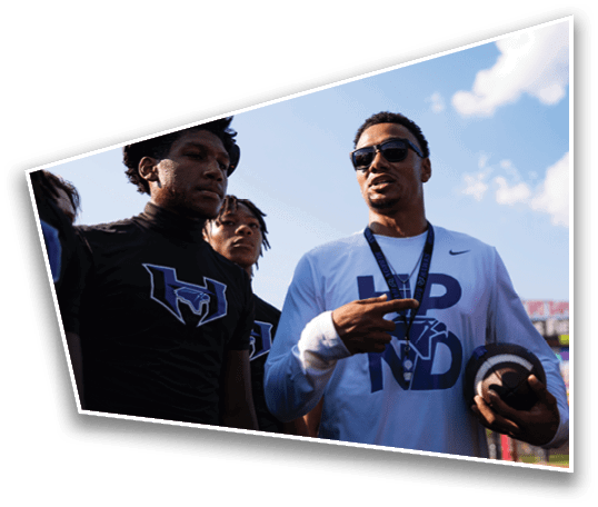 A group of people wearing football helmets and white jerseys with “Yorba Linda" written on them stand together outdoors in sunlight. Description generated by AI