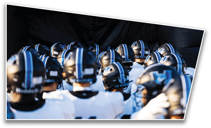 A group of people wearing football helmets and white jerseys with “LA LINDA" written on them are standing closely together on a field. Description generated by AI