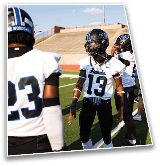 A person wearing a football helmet and a white Yorba Linda jersey with the number 26 stands outdoors with a blurred green background. Description generated by AI