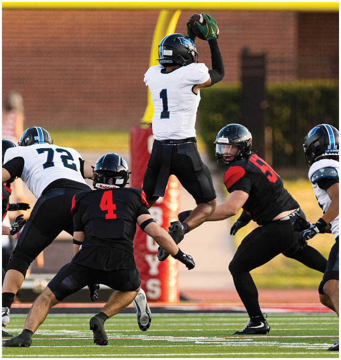 A group of football players wearing black and white uniforms. Description generated by AI