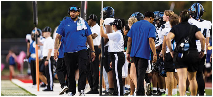 A group of football players on a field. Description generated by AI