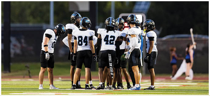 A group of football players on a field. Description generated by AI