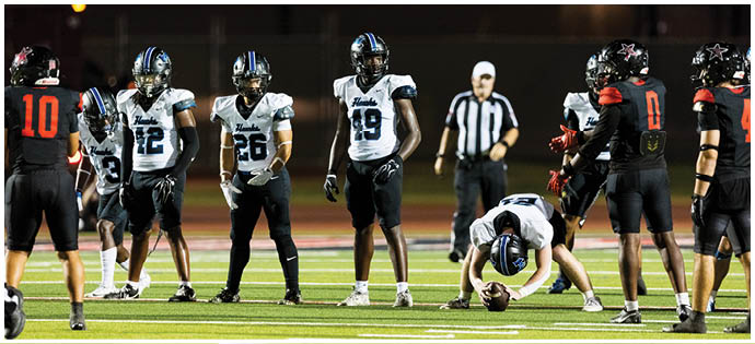 A group of football players on a field. Description generated by AI