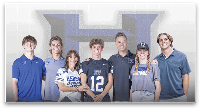 Seven people standing closely together smiling, wearing casual and sports-themed clothing, with a large stylized letter “H" in the background. Description generated by AI