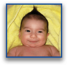A person is wrapped in a yellow towel with only the top of the towel visible against a neutral background. Description generated by AI