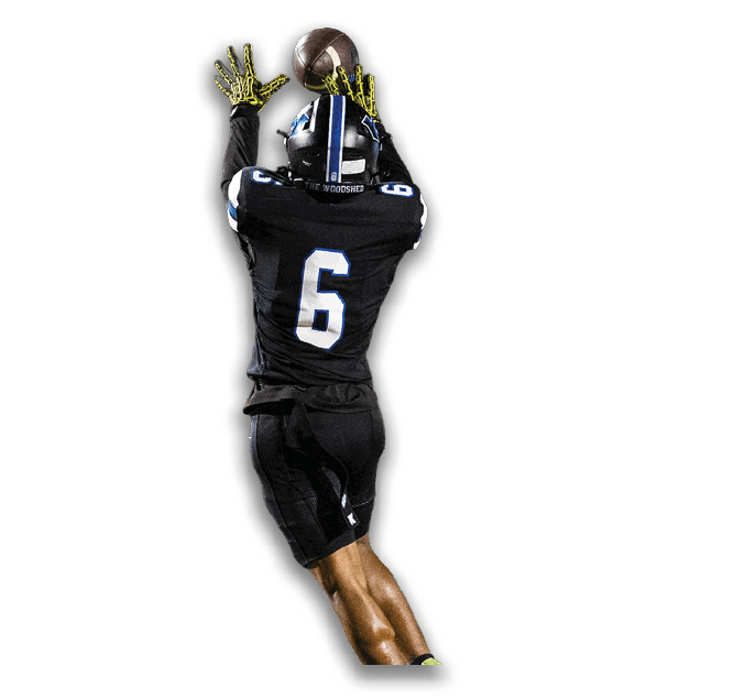 A person wearing a black football uniform with the number six is reaching up with both hands to catch a football. Description generated by AI