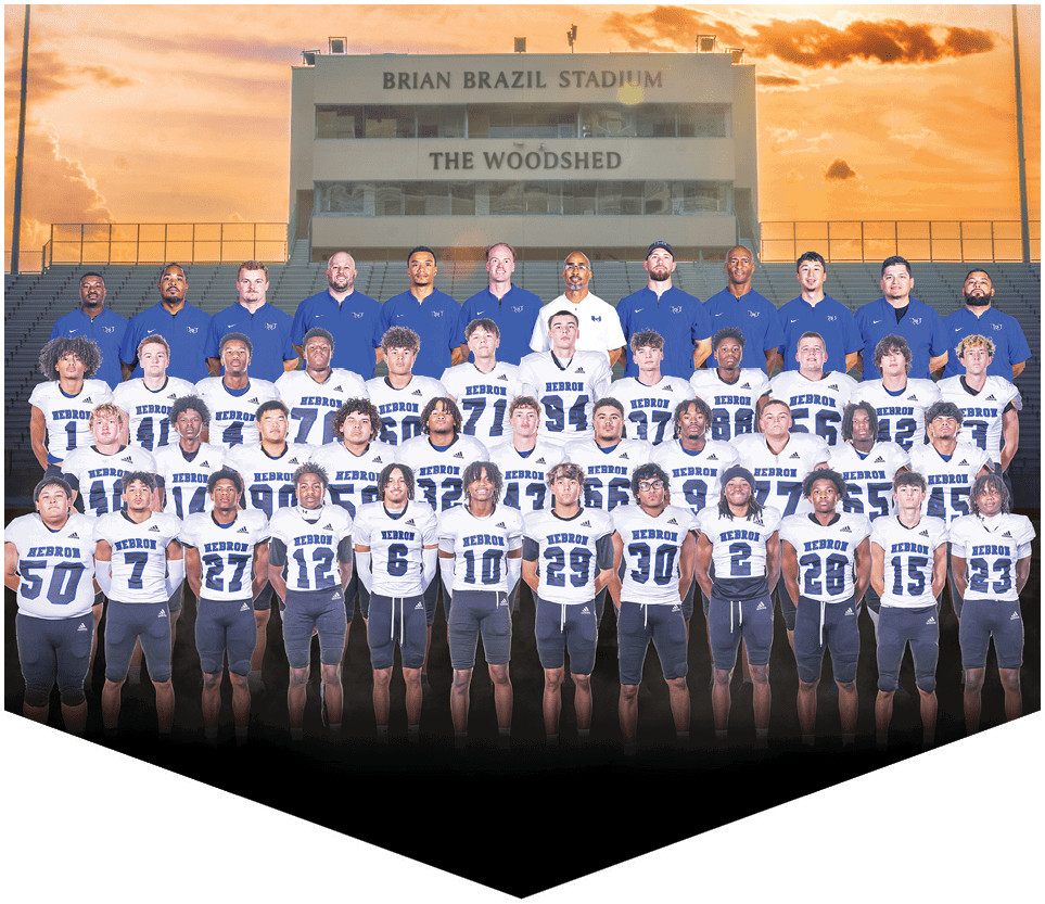 A large group of people wearing matching sports uniforms and coaches in blue shirts pose together in front of stadium bleachers at sunset. Description generated by AI