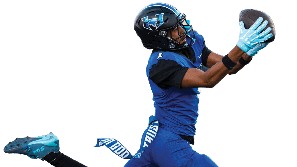 A person wearing a blue sports jersey and a black football helmet with a blue and white logo is looking to the side. Description generated by AI