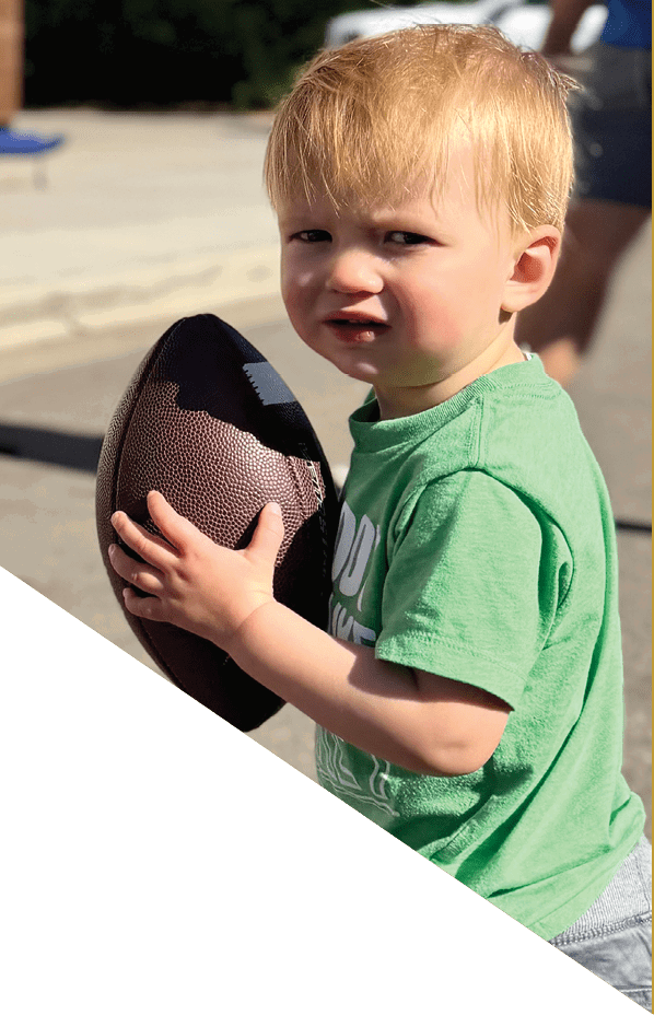 A football player is kneeling on the field, holding his helmet in his hands. AI generated content