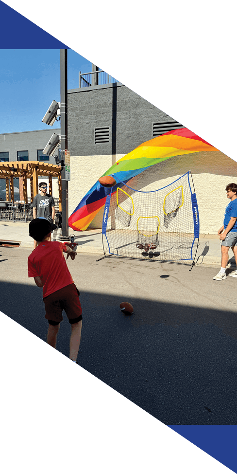 Two men are jumping in the air on a field, both wearing football uniforms. AI generated content