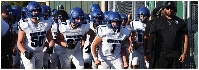 A group of football players on a field. Description generated by AI