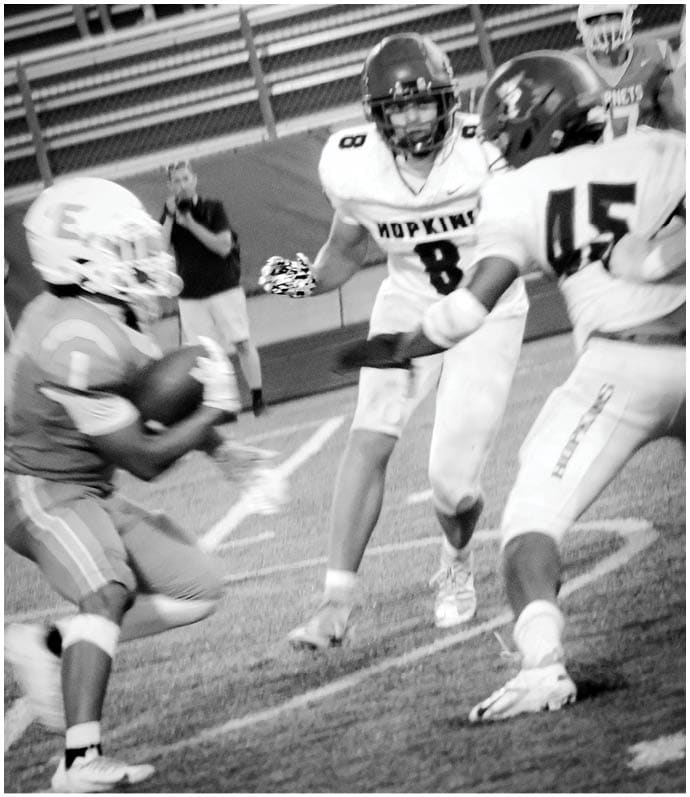 A group of football players wearing black and white uniforms. Description generated by AI