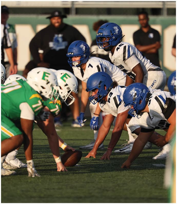 A group of football players wearing black and white uniforms. Description generated by AI