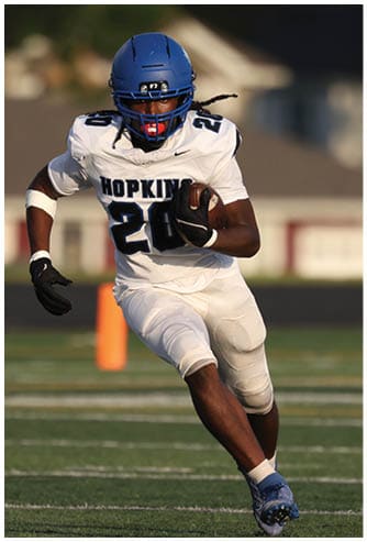 A football player running on the field. Description generated by AI