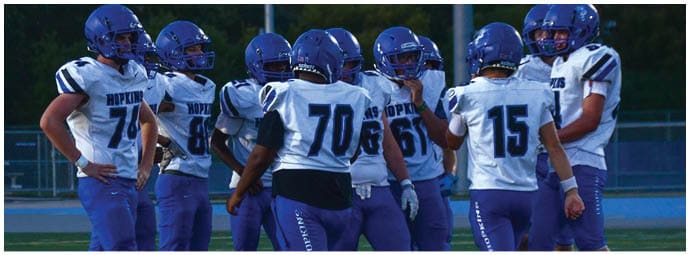 A football player wearing a blue and white uniform. Description generated by AI