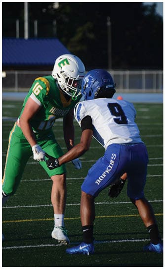 A football player catching a ball. Description generated by AI