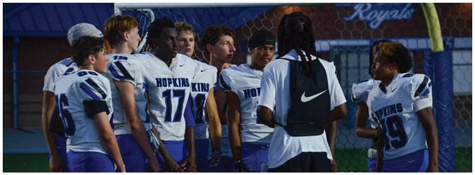 A football player wearing a blue and white uniform. Description generated by AI