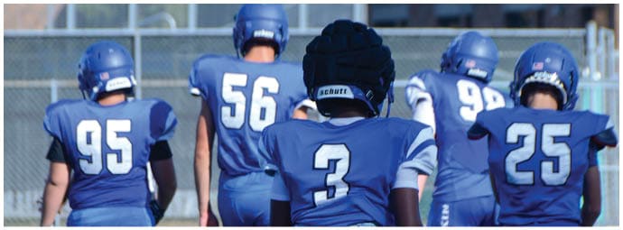 A football player wearing a blue and white uniform. Description generated by AI
