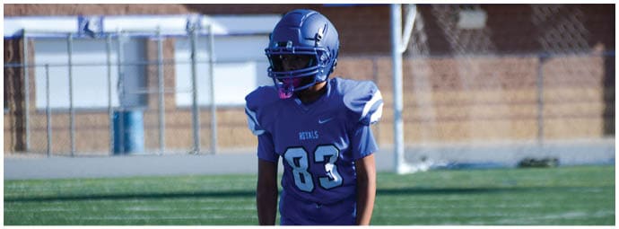 A football player wearing a blue and white uniform. Description generated by AI